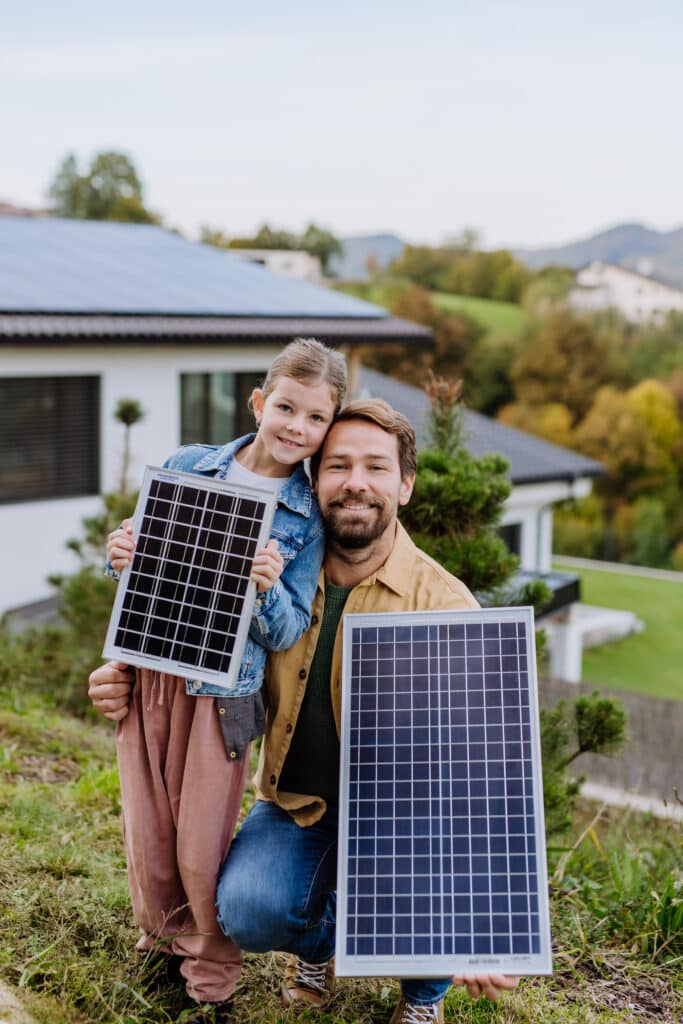 Vater und Tochter halten kompakte Solarmodule